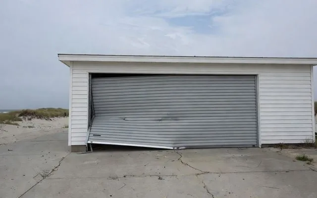 A roller door pulled from its guide by wind